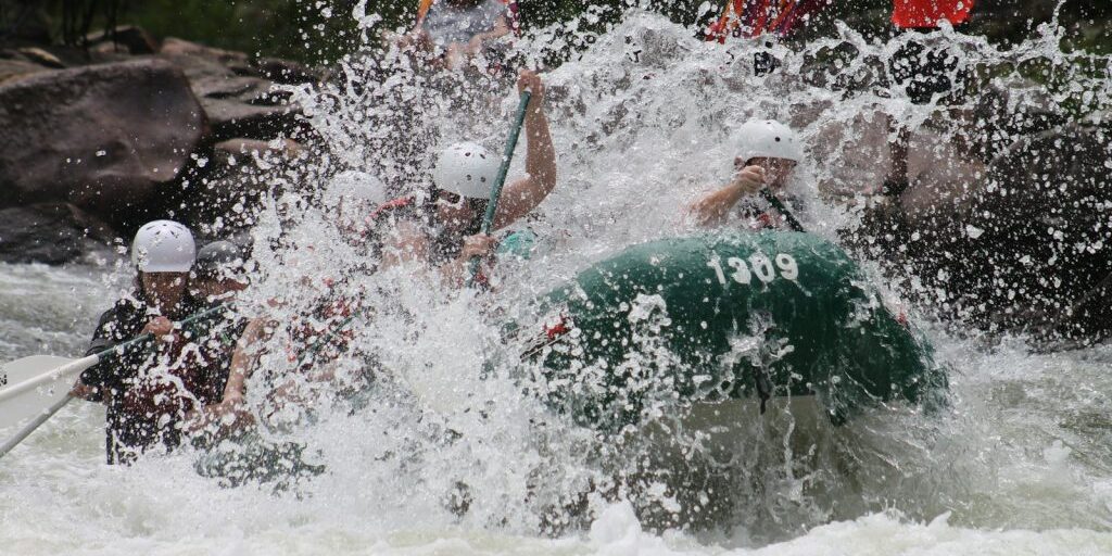 people in boat rowing raft