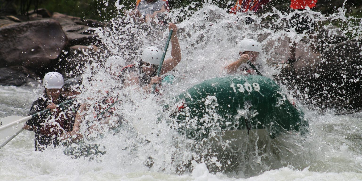 people in boat rowing raft